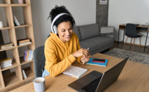 young girl with headphones working on a laptop