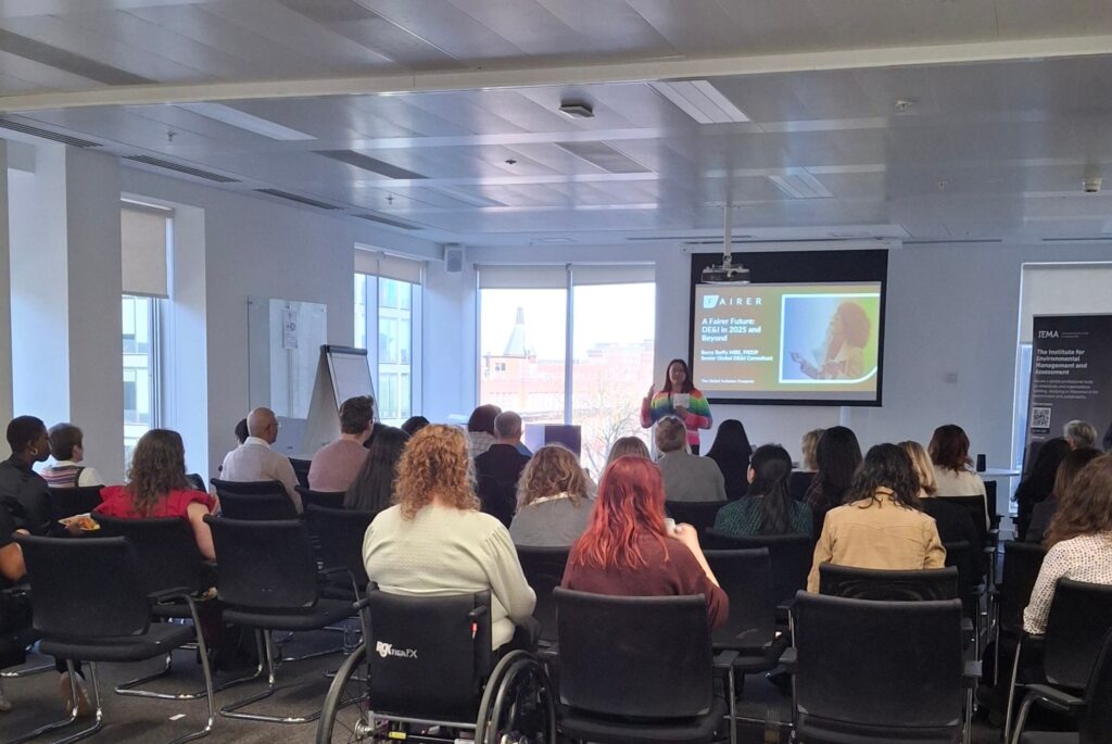 Photo at the DSI event in March 2025. A group of people are watching a speaker present