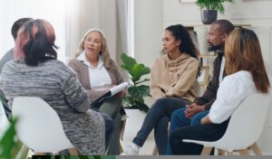 A diverse group of people in a small support group sat around in a circle talking to each other